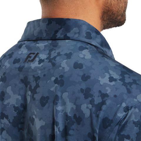 Close-up of a man's neck and shoulders wearing the FootJoy Men's Pop Camo Lisle Polo in Dark Denim, featuring blue camo and an embroidered FJ logo for a stylish, comfortable golf look.