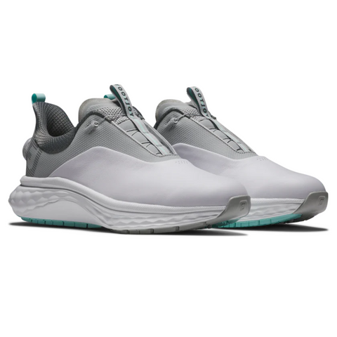 The FootJoy Men's Quantum Boa Golf Shoes in White/Grey/Teal feature a modern slip-on design, textured soles, teal pull tabs, and a wavy midsole for a precision fit, shown here on a white background.