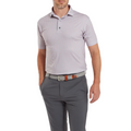 A man wears a light purple FootJoy Men's Scallop Shell Foulard Lisle Polo, dark gray pants, and a black-and-white woven belt with brown accents. The moisture-wicking lisle polo by FootJoy keeps him comfortable and stylish.