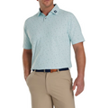 Model wearing the FootJoy Tweed Texture Polo in light mint green, paired with beige pants. The polo features a subtle tweed-like pattern with small, colorful specks. It has a button-up collar and short sleeves, with the FootJoy logo visible on the collar. The model has one hand in his pocket.