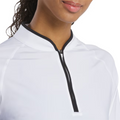 A woman with medium brown skin, smiling slightly, wears the FootJoy Women's Quarter-Zip Long Sleeve Sun Protection Shirt in white with a black-edged collar, enjoying UPF 50+ protection.