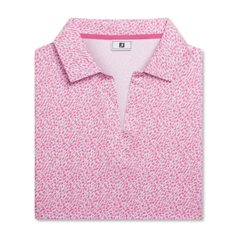 The FootJoy Women’s Cap Sleeve Print Shirt in Pink Lemonade features an abstract dotted pattern, moisture-wicking fabric, short sleeves, and an FJ logo on the inside collar, shown folded against a white background.