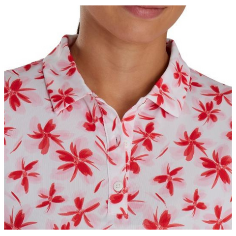 Close-up of a FootJoy Women's Long Sleeved Floral Shirt in red/pink, showing the collared design, buttons, and floral patterns, with the person's face partially visible.