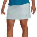 A woman wears a FootJoy Womens Performance Knit Skort in light green, pink, and white plaid with a teal top, shown from waist to mid-thigh with arms relaxed.