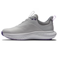 A side view of the FootJoy Women's Quantum Golf Shoes in Grey/White/Purple shows a light gray sneaker with purple accents, a thick white textured sole, and a seamless design, featuring OrthoLite FitBed cushioning for superior comfort.