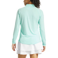 A woman with her back to the camera wears a FootJoy Womens 1/4 Zip Long Sleeve Sun Protection Shirt in light blue and white stripes, paired with a white skirt—ideal for comfortable, stylish days on the golf course.