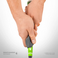 Close-up of two hands using the Golf-Grip Training Aid by Golf-Grip to show a right-handed grip on a green golf club, left hand above right. Text: RIGHT-HANDED SHOWN and *GREEN GOLF CLUB NOT INCLUDED.