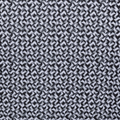 A close-up of the Greg Norman Men’s Great White Mosaic Ultra Stretch Polo in black and white shows interlocking geometric shapes forming a uniform, optical illusion pattern throughout the shirt.
