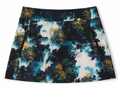 Greg Norman women's abstract floral golf skort in black, turquoise, white and ochre, front view