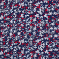 The Greg Norman Women’s Play Dry Prestige Camo Floral Polo in Navy/Red features a small white and red floral camo print on dark blue, offering style and breathability—perfect for your next round of golf.