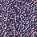 Close-up of a zippered fabric from the Greg Norman Women’s Play Dry Prestige Camo Floral Polo in Navy/Red, featuring a dense camo floral pattern and center zipper detail, inspired by women’s golf shirts.