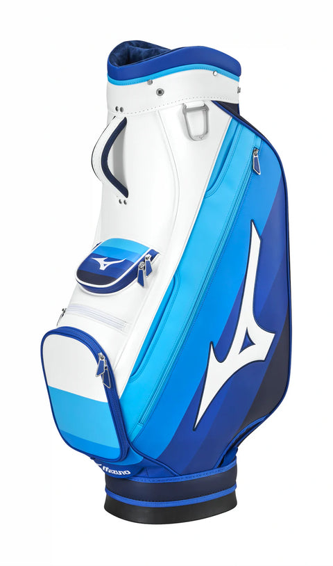 The Mizuno 2025 Tour Cart Bag by Mizuno features a white, blue, and navy design with silver zippers, a large side logo, multiple zippered compartments, and a top carry handle.
