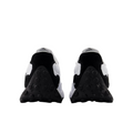 The New Balance 327 Womens Golf Shoes in white and black are shown from the back, highlighting the heels and textured black soles with circular patterns against a white background.