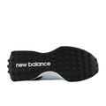 The image shows the black rubber outsole of the New Balance 327 Womens Golf Shoes - White/Black, with raised circular grips and a white New Balance logo, highlighting the shoes retro-inspired, spikeless golf design.