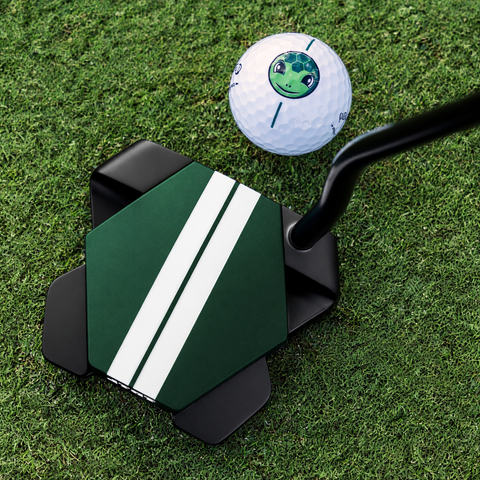 Odyssey TRTL Double Bend left-hand putter behind a golf ball on the green, showing Twin Track alignment; digitally adapted to left-hand orientation