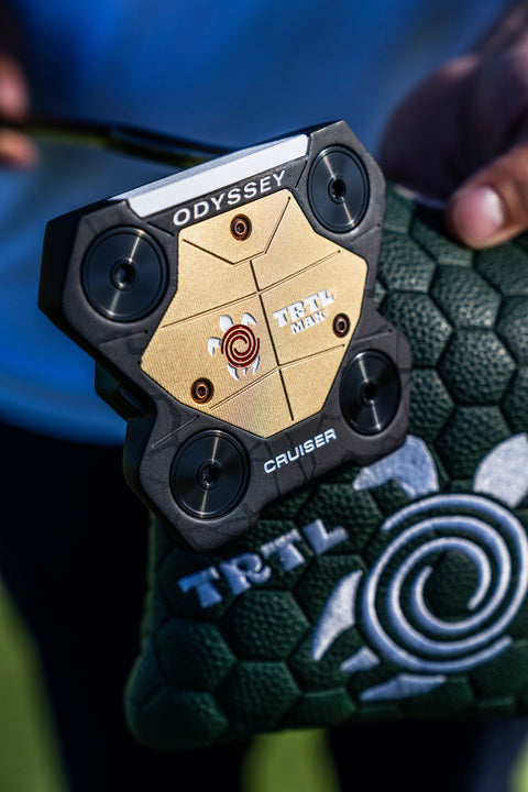 Odyssey TRTL Max Cruiser sole and adjustable weights photographed above its green headcover