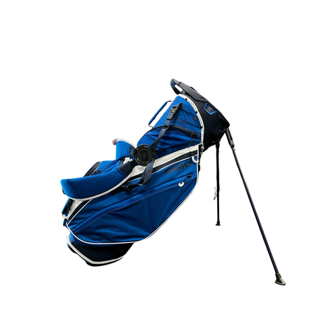 A Ogio 2026 Silencer Hybrid Bag in Volcanic color, featuring white and black accents for club security, stands open on two legs against a white background.