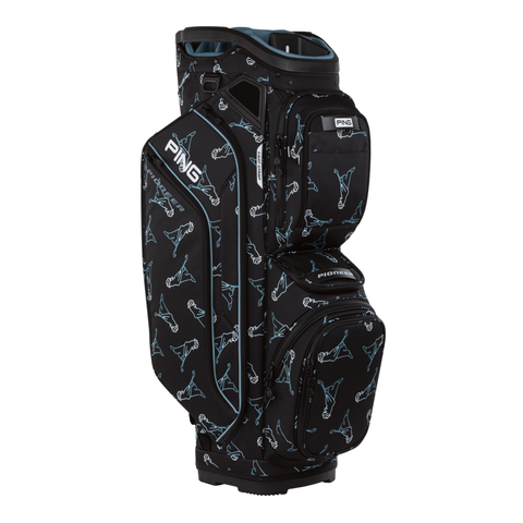 The PING 2026 Pioneer 244 Cart Bag in Mr PING Black/Blue features a 15-way top, multiple zippered pockets, and a repeating pattern of outlined golfer silhouettes in white and blue.