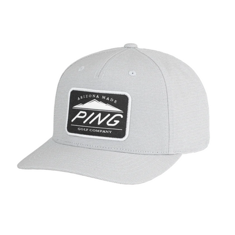 Stay cool and dry in the PING Camelback Patch Cap by Ping—a light gray, flat-brim golf cap with a black patch reading Arizona Made PING Golf Company in white. Features moisture-wicking fabric for comfort on the course.