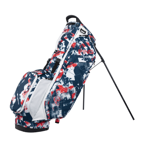 The PING Hoofer 231 Stand Bag | National Graffiti by Ping is a lightweight golf bag in blue, white, and red abstract pattern, featuring multiple zippered pockets, a top handle, two support legs, and visible branding on the side.