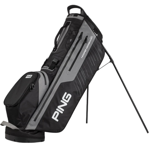The black and gray Ping Hoofer Monsoon Stand Bag features a stand, multiple zippered pockets, waterproof design, and the prominent Ping logo on the side.