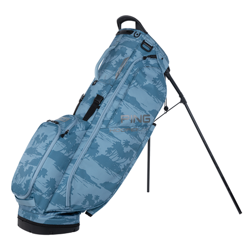 The PING HooferLite 231 Stand Bag in Blue Isles features a camouflage pattern, multiple zippered pockets, an extended stand for upright storage, and the Ping logo displayed on the side.