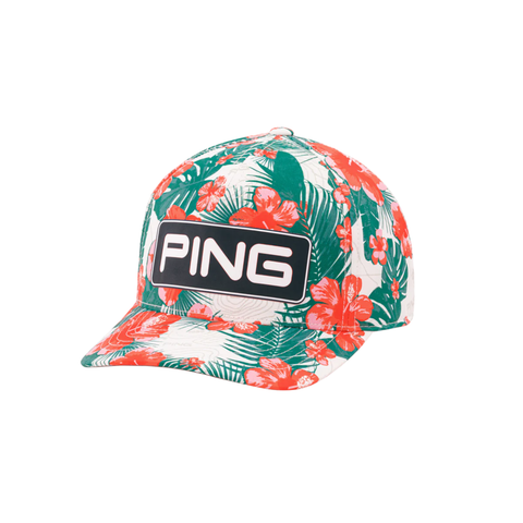 Front view of the Ping Pua Tour Snapback cap featuring a vibrant floral pattern with red hibiscus flowers and green leaves on a white background, with a prominent white on black Ping logo on the front.