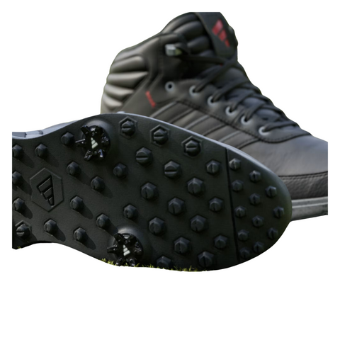 Close-up view of the Adidas S2G RAIN.RDY golf shoes. The black outsole features small, multidirectional rubber lugs for enhanced grip and stability on wet terrain. The high-top shoe is made with waterproof materials, offering weather protection.