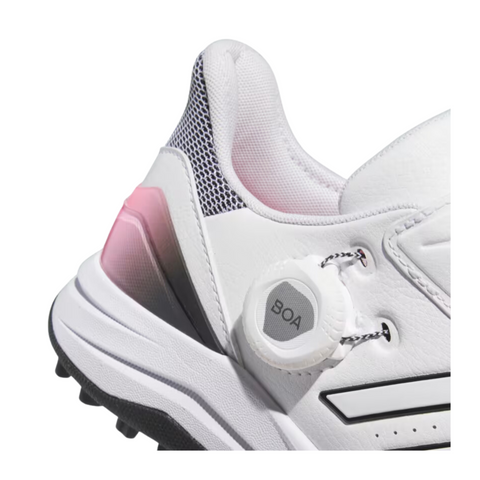 Close-up of the Adidas Solarmotion BOA 2024 spikeless women's golf shoes. The BOA dial system is prominently featured on the side for a customizable fit. The heel area showcases a mesh panel with a gradient fade from pink to black, enhancing breathability and style. The heel's base is reinforced for added stability.