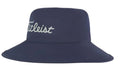 The Titleist 2023 Stadry Bucket Hat is a navy waterproof golf hat with a wide brim and Titleist in white cursive on the front—ideal for staying dry on rainy days.