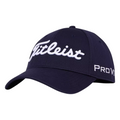 The Titleist 2024 Tour Elite Cap is a navy blue, tour-level golf hat with a white embroidered Titleist logo on the front and Pro V1 on the side, shown angled to the left.