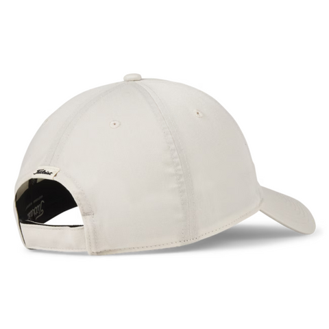 The Titleist 2025 Montauk Lightweight Cap in light beige, shown from the back, has an adjustable strap and a black-and-white label above the opening—ideal as a lightweight golf hat on or off the course.