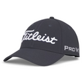 The Titleist 2025 Tour Performance Cap is a dark gray golf hat with white Titleist script on the front and Pro V1 on the side. It features a curved brim and ventilation holes for comfort during play.