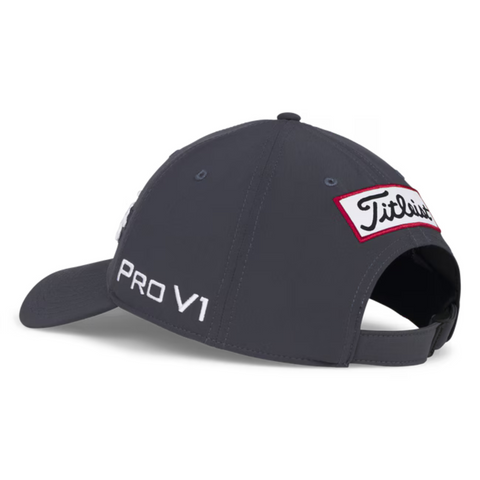 The Titleist 2025 Tour Performance Cap in dark gray is shown from the back and side, featuring a white PRO V1 logo on the side and a red-edged Titleist patch above its adjustable black strap—an essential golf hat for performance.