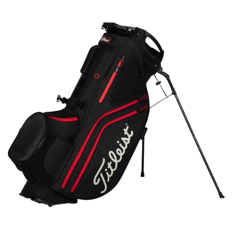 The Titleist Hybrid 14 Golf Bag is a lightweight black and red bag with a 14-way top divider, two extended legs, large side pockets, and the Titleist logo—designed for convenience and style on the course.