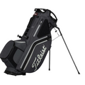 The Titleist Hybrid 14 Golf Bag, in black with white accents, features a 14-way top divider and stand legs. Lightweight and secure, its perfect for carrying clubs and equipment on the course.
