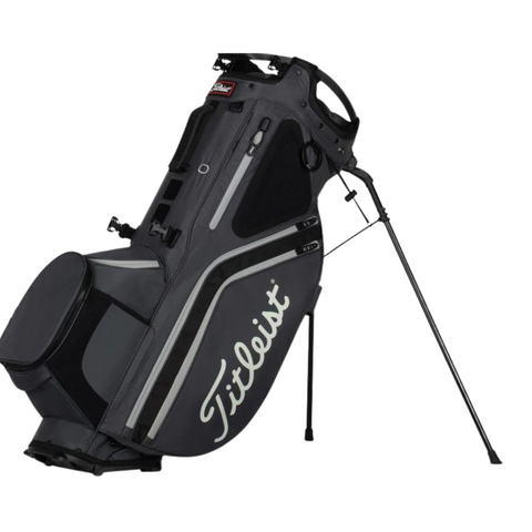 The Titleist Hybrid 14 Golf Bag, in black with white accents, features a 14-way top divider and stand legs. Lightweight and secure, its perfect for carrying clubs and equipment on the course.