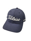 The Titleist Junior Tour Performance Cap is a navy blue kids’ golf cap with white “Titleist” embroidery on the front and “PRO” at the brim. It features visible stitching and a curved bill for classic style.