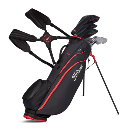 A black and red Titleist Players 4 Carbon Stand Bag by Titleist, shown upright with clubs on its extended legs, highlights the ultralight golf bag design against a white background.