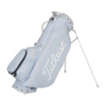 The Titleist Players 5 Stand Bag in light blue features white detailing, a large Titleist logo, multiple zippered pockets, and sturdy white-legged stand—a premium choice for golfers.