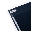 A close-up of the Titleist Players Terry Towel by Titleist, featuring a textured, absorbent dark blue terry surface, white stripe, and a sewn-in logo tag on one corner.