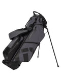 The Travis Mathew Golf BYOB Stand Bag in heather dark grey, featuring a lightweight design, dual stand legs, and a shoulder strap, is shown upright against a white background.