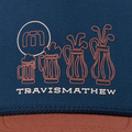 The Travis Mathew Beerly Beloved Snapback Hat in Titan Blue features a blue fabric, outlined four golf bags and beer mug logo, stylized TM in a white circle above the mug, and the brand name in white below.