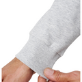 A close-up of a hand pinching the ribbed cuff of the TravisMathew Cloud 1/4 Zip 2.0 Men’s Pullover in Heather Light Grey by Travis Mathew.