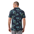 A man with short hair stands with his back to the camera, wearing a Travis Mathew Men’s Favourite Hello Polo in Total Eclipse Blue and light gray pants.