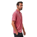 A man with short dark hair and a beard wears the TravisMathew Mens The Heater Polo in Heather Scooter by Travis Mathew, made from breathable performance fabric, standing sideways and looking ahead against a plain white background.