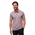 Model wearing the TravisMathew New Destination Polo in muted purple, featuring short sleeves, a three-button placket, and a relaxed fit. The subtle heathered texture adds a modern touch, suitable for both casual and performance wear.