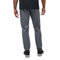 A man faces away from the camera in TravisMathew Open To Close Men's Jogger by Travis Mathew, pairing sleek gray joggers with a black shirt and sneakers.