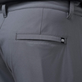 Close-up of the back pocket on Travis Mathew Open To Close Men's Jogger pants in gray, featuring a small black tag with a white m logo near the pockets top.