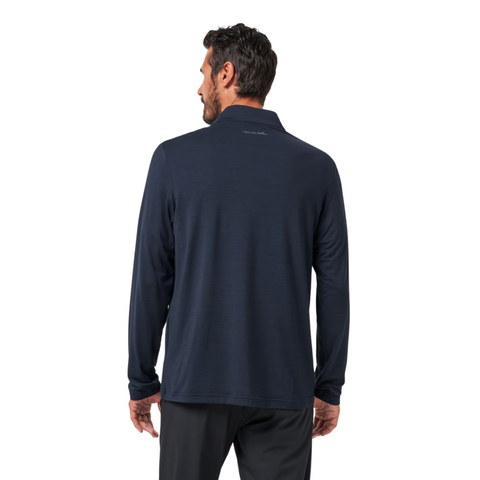 A man stands with his back to the camera, wearing a TravisMathew The Heater Quarter Zip Mens Long Sleeve Polo by Travis Mathew and black pants against a plain white background.